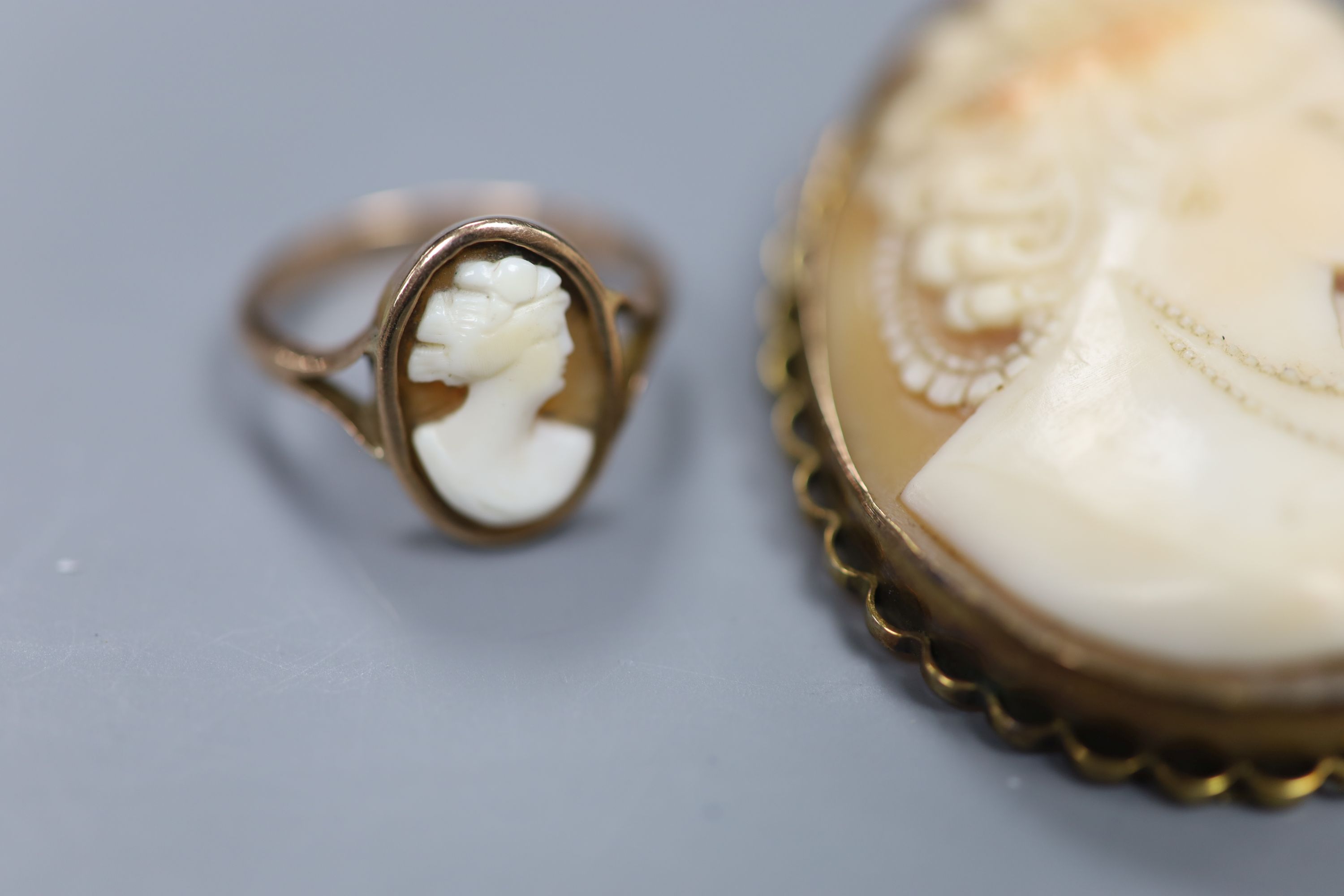 A 9ct mounted oval cameo shell brooch, 47mm, gross12.6 grams, two rings including 9ct cameo and yellow metal and jade and a brooch.